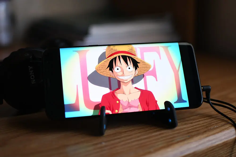Menikmati Anime di Ponsel Android Seseorang menonton anime di ponsel Android